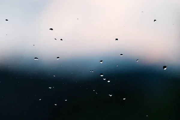 冬にオーストラリアのタスマニアで撮影された背景に焦点を当てていない山の上に雲と窓の雨滴 — ストック写真