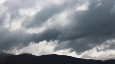 Günün zamanı geçiyor ve bulutlar dağların üzerinden yuvarlanıyor ve kışın Tazmanya, Avustralya 'da yoğun bitki örtüsü vuruyor.