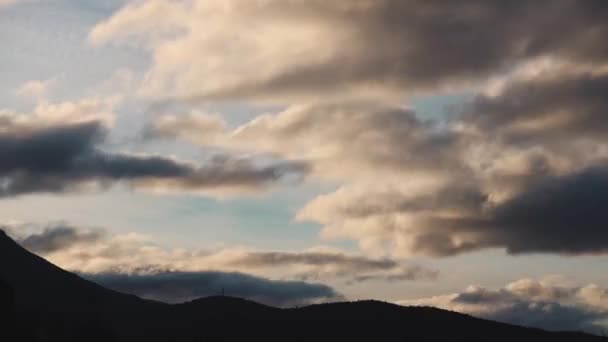 冬にオーストラリアのタスマニアで撮影された山と厚さのある植生を覆う黄金の夕日と雲のタイムラプス — ストック動画