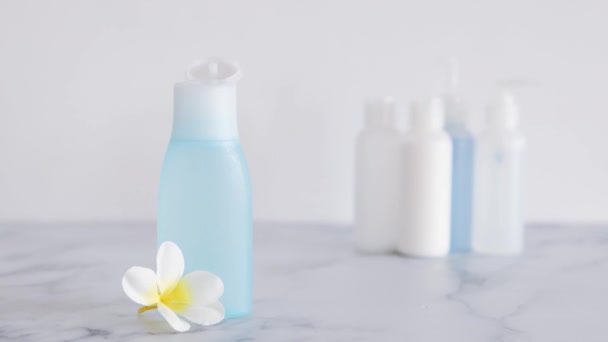 低毒力 无毒的自然美产品概念图 手工将花放在蓝色乳液瓶前面的前景与其他瓶不同 — 图库视频影像