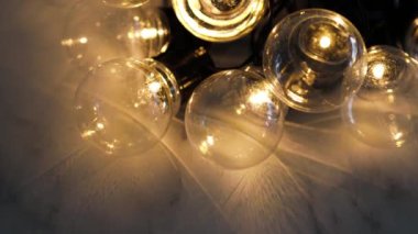 Parlak ışıklı ampuller mermer arka planda birbirine dolanmış, beyin fırtınası fikri ve takım çalışması kavramı. 