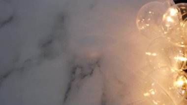 Parlak ışıklı ampuller mermer arka planda birbirine dolanmış, beyin fırtınası fikri ve takım çalışması kavramı. 