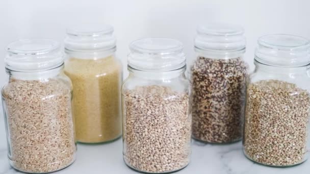 Heldere Pantry Potten Met Verschillende Soorten Granen Waaronder Quinoa Rijst — Stockvideo