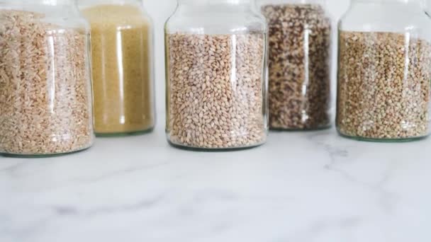 Heldere Pantry Potten Met Verschillende Soorten Granen Waaronder Quinoa Rijst — Stockvideo