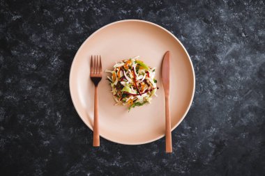 Ortasında az miktarda salata olan büyük tabak, diyet ve kalori kısıtlamaları kavramı