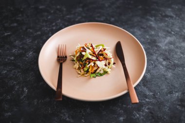 Ortasında az miktarda salata olan büyük tabak, diyet ve kalori kısıtlamaları kavramı