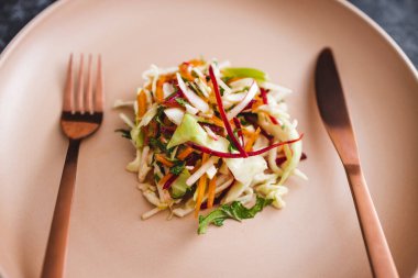 Ortasında az miktarda salata olan büyük tabak, diyet ve kalori kısıtlamaları kavramı