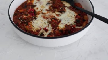 Biberli, sütsüz kremalı, sağlıklı bitkisel yemek tarifleriyle kaplı vegan beyaz fasulyeli shakshuka ve zeytin.