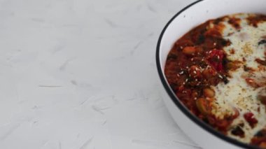 Biberli, sütsüz kremalı, sağlıklı bitkisel yemek tarifleriyle kaplı vegan beyaz fasulyeli shakshuka ve zeytin.
