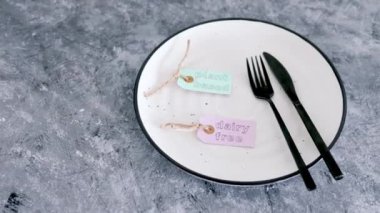 Yemek tabağının tepesinde çatal ve bıçakla bitkisel ve mandırasız ürün etiketi, sağlıklı beslenme kavramı ve etik tercihler