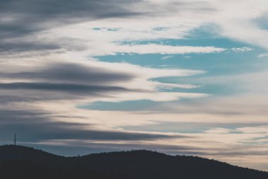 Kışın Tazmanya dağları üzerinden gelen ve giden güzel zıt bulutlar.