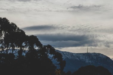 Tazmanya, Avustralya 'da kışın yoğun bitki örtüsüyle çevrili karla kaplı tepeler