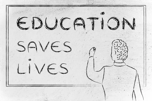 Teacher writing on blakboard: education saves lives — Zdjęcie stockowe