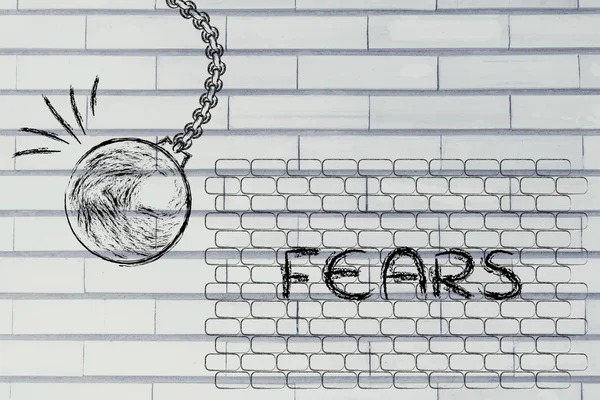 Wrecking ball about to destroy a wall with the text Fears — 图库照片