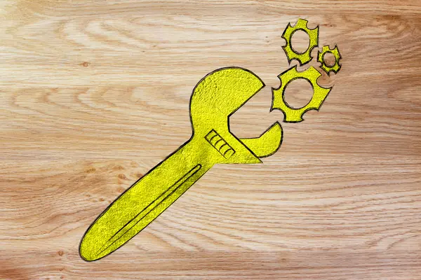 Golden wrench fixing a set gearwheels — Stock Photo, Image