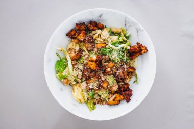 healthy green cabbage and iceberg lettuce salad with roasted teriyaki tofu and cashew dukkah, a high protein plant based meal for diabetes and general wellness