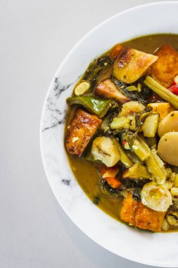 Tofu ve krema aromalı soslu karışık sebzelerle yapılan vejetaryen yeşil köri, sergilenen bitki yemekleri, Tayland 'dan esinlenilen tatlar ve sağlıklı ev yapımı konforlu yemekler.