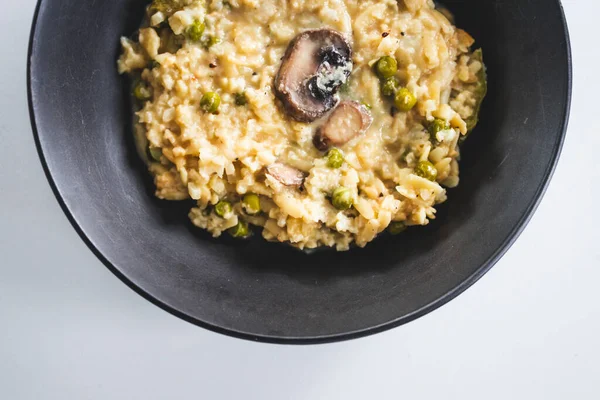 Mantar ve bezelye soslu kremalı risoni makarna, rahatlatıcı vejetaryen yemekleri, sağlıklı malzemeler ve ev yapımı Akdeniz tarzı tatlar sergileniyor.