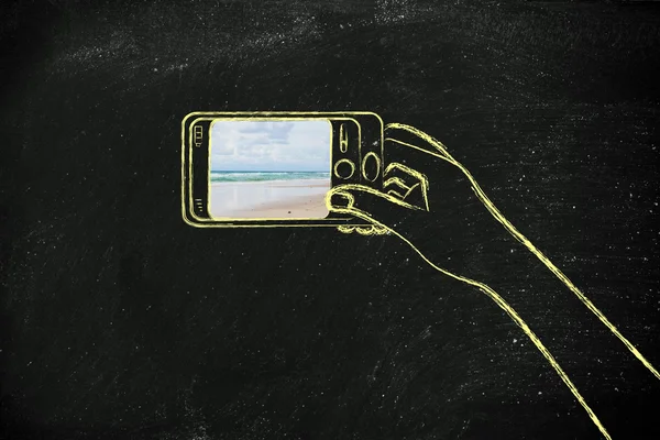 Hand som håller spmartphone med beach bild på skärmen — Stockfoto