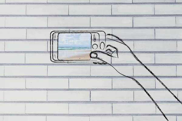 Main tenant smartphone avec photo de plage sur l'écran — Photo