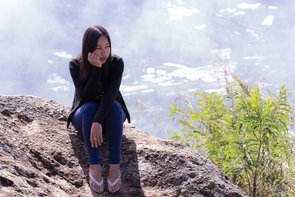 Thaise vrouw met rugzak zittend op de klif — Stockfoto