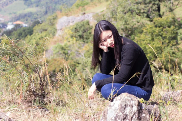 Thaise vrouw met rugzak zittend op de klif — Stockfoto