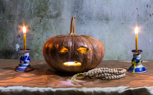 Halloween-Stillleben mit Kürbissen, Kerzen und Rosenkranz — Stockfoto