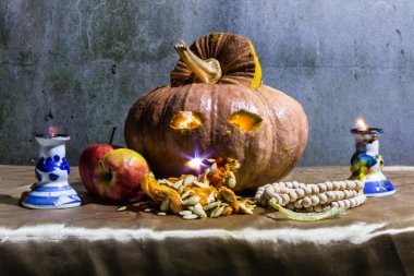 Halloween pumpkins, elma, mumlar ve tesbih ile natürmort
