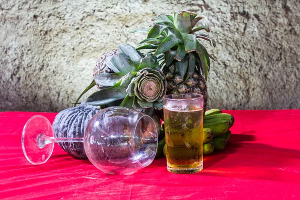 Stilleven kunst fotografie op banaan pompoen glas bier en pine Stockfoto
