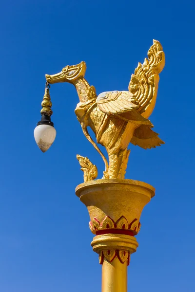 Золотая тайская фигурка лебедя с лампой в голубом небе — стоковое фото