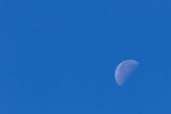 Meia lua no céu azul — Fotografia de Stock