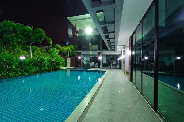 Дом с бассейном ночью — стоковое фото