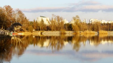 Gölün diğer tarafında gün batımında yanan ağaçlar.