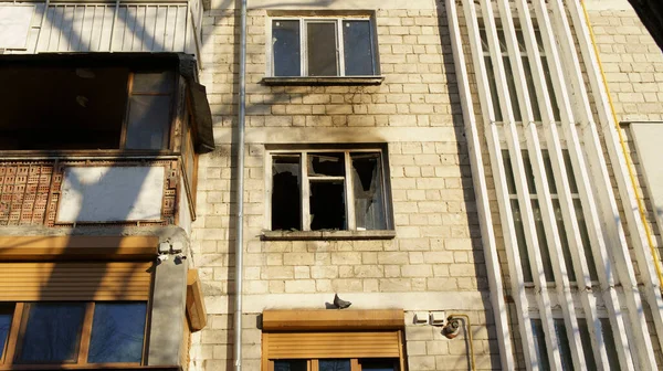 Apartman bloğundaki yangından sonra balkon manzarası ve kırık bir pencere