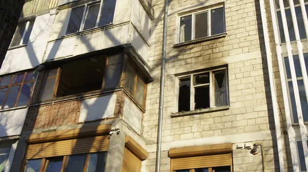 Apartman bloğundaki yangından sonra balkon manzarası ve kırık bir pencere