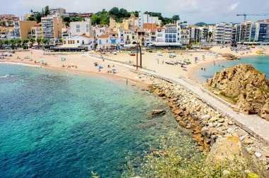 Turistler, İspanya 'nın güzel bir yaz gününde Costa Brava' nın Blanes plajında eğleniyorlar.