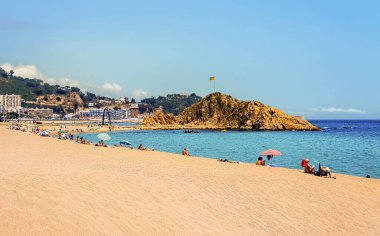 Turistler, İspanya 'nın güzel bir yaz gününde Costa Brava' nın Blanes plajında eğleniyorlar.