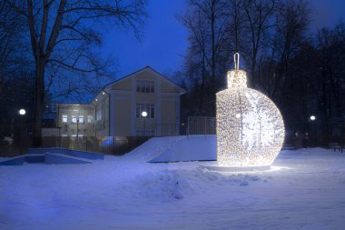 Şehir parkındaki yeni yıl süslemeleri ve dekorasyonları için altın Noel baloları.
