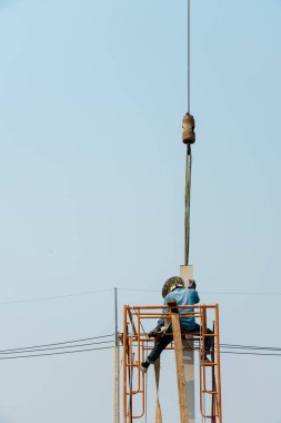 Mobil Crane işçilerin H-ışını direğini yerleştirmesine yardım etti.