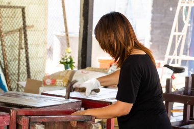 Eldivenli bir kadın çekiçle masayı tamir ediyor. Çekiç hareketi bulanıklığı.