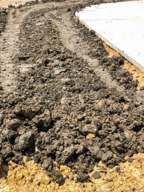 Traktör tekerlek izleri var. Beton yolun yanında..