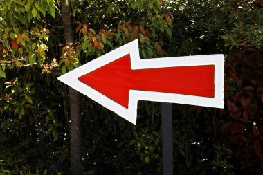 Sol ve yeşil bitkileri gösteren bir tahta ok işareti.