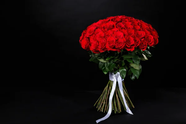 Bouquet of 101 red roses, place for the logo on a black studio b — Stock Photo, Image