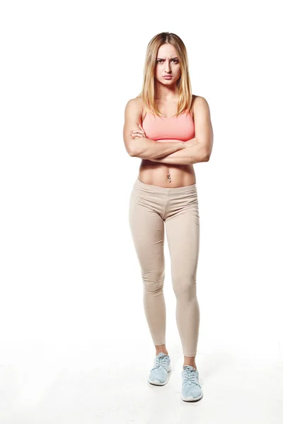 Beautiful young girl with a sports body, on white studio background, with an evil emotion — Stock Photo, Image