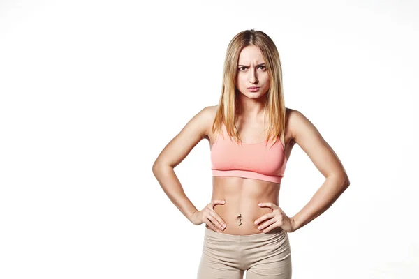 Hermosa joven con un cuerpo deportivo, sobre fondo de estudio blanco, con la emoción del mal — Foto de Stock