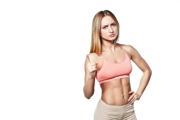 Beautiful young girl with a sports body, on white studio background, with evil emotion — Stock Photo, Image