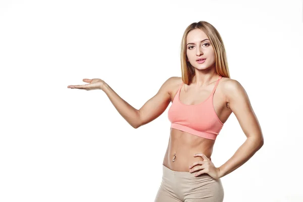 Hermosa joven con un cuerpo deportivo con la mano levantada, en un estudio blanco espacio de fondo para su logotipo — Foto de Stock