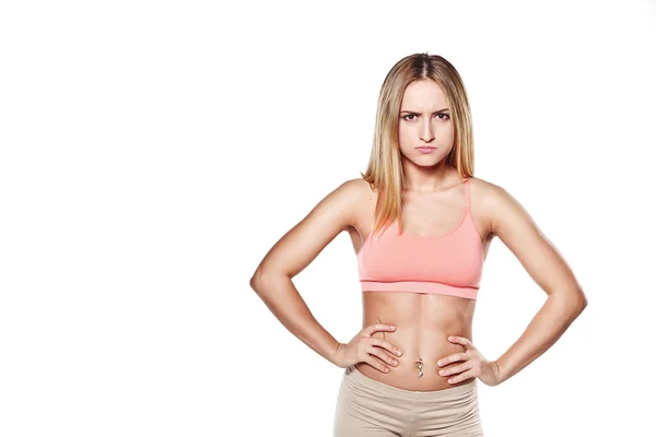 Hermosa joven con un cuerpo deportivo, sobre fondo de estudio blanco, con una emoción maligna — Foto de Stock