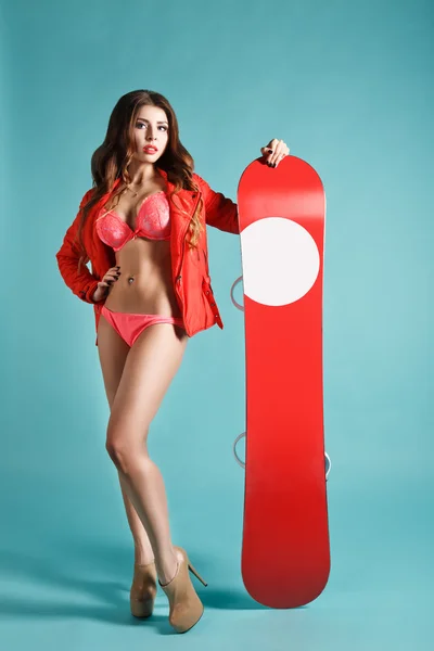 Atrakcyjne młode Sexy dziewczyna w Bikini trzymając czerwony Snowboard zima tło. Przestrzeń dla Twojego logo. Studio fotografii. Idealne rozwiązanie dla reklamy — Zdjęcie stockowe