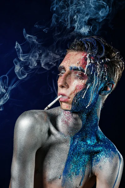 Pazzo giovane uomo con viso arte fumare e godere. Persona strana — Foto Stock